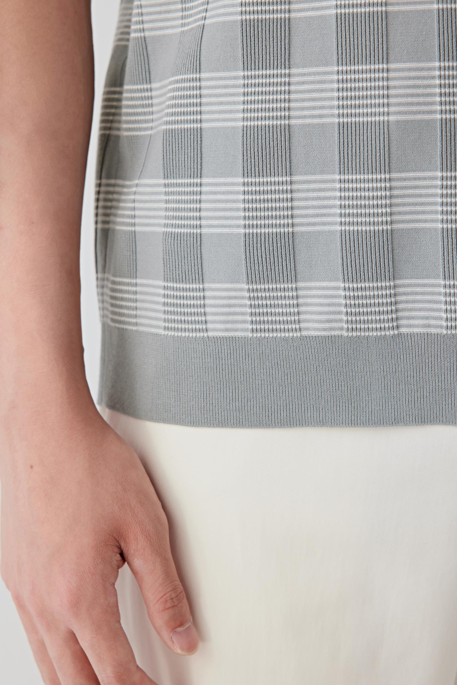 Close-up detail of the sleeve and side body highlighting the texture of the knit, subtle pattern contrast and smooth finishing at the edges.