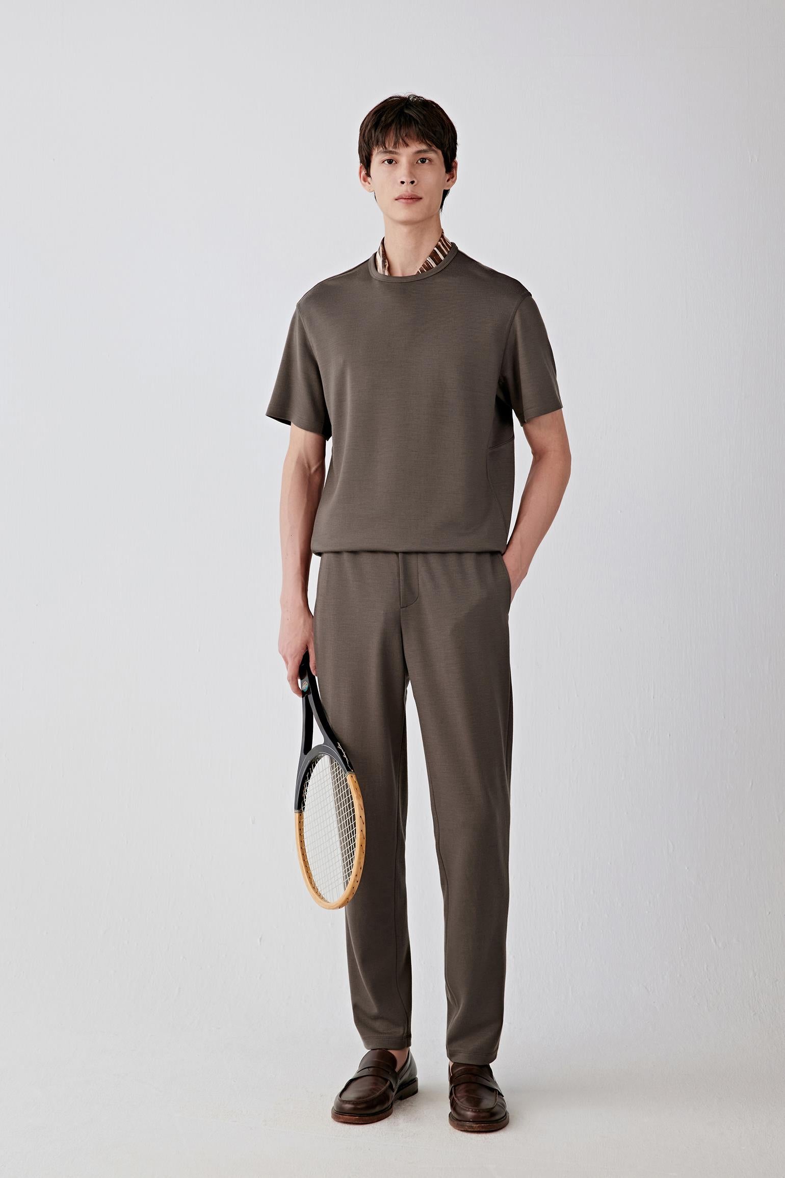 Man wearing brown Ponte de Roma wool trousers with a matching top, full-length front view.