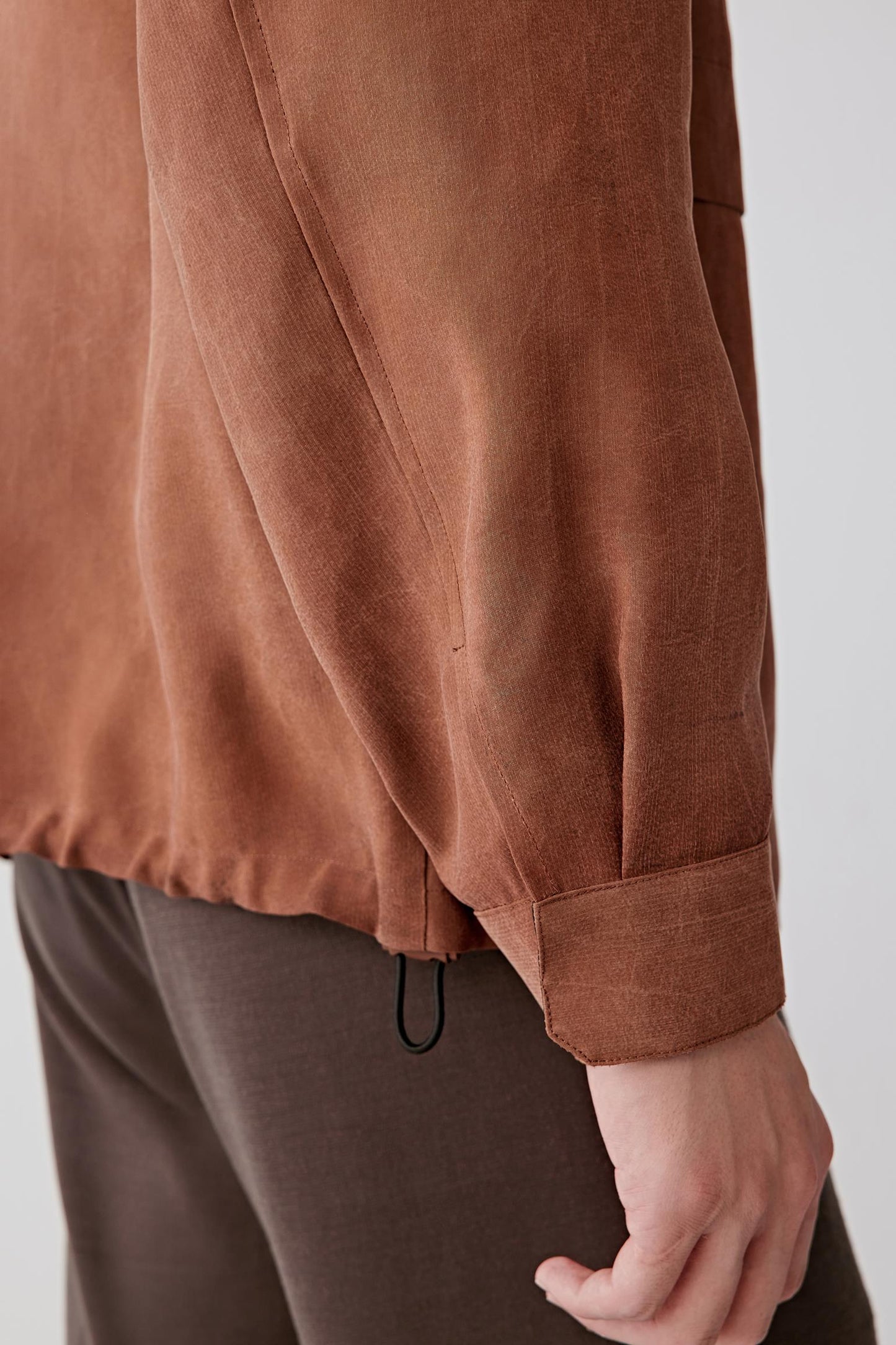 Detail of sleeve and fabric surface, revealing subtle texture and natural finish.