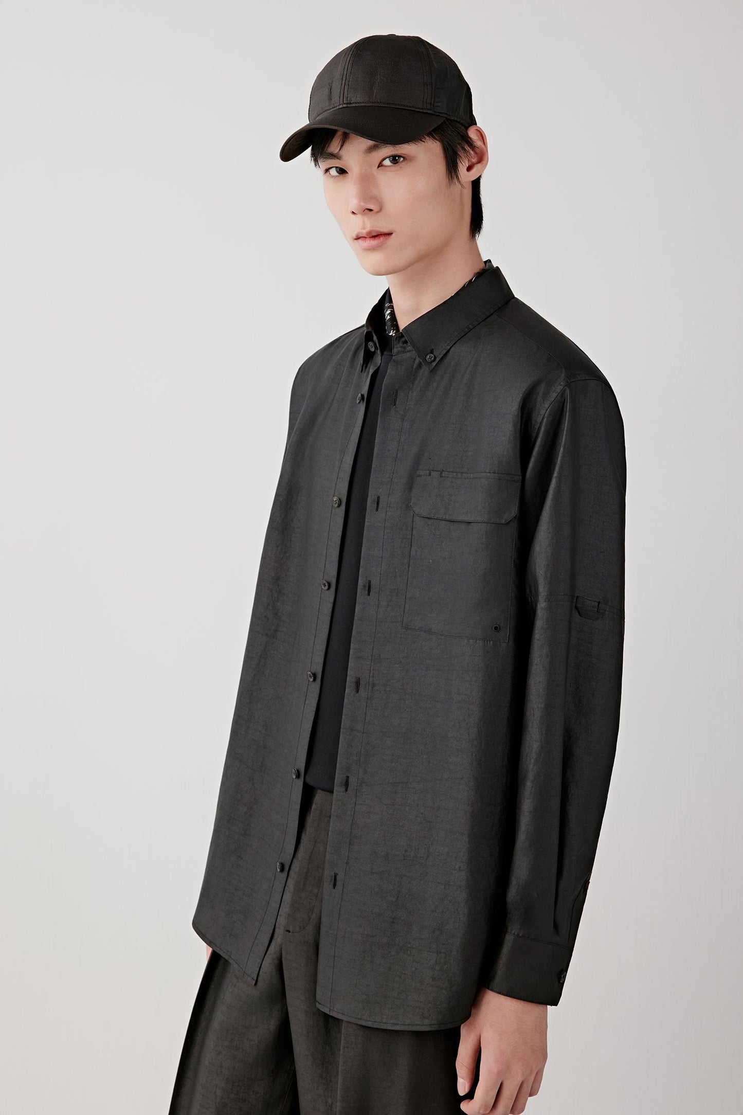 Front three-quarter view highlighting the buttoned front, straight fit through the torso and lightweight structure of the fabric.