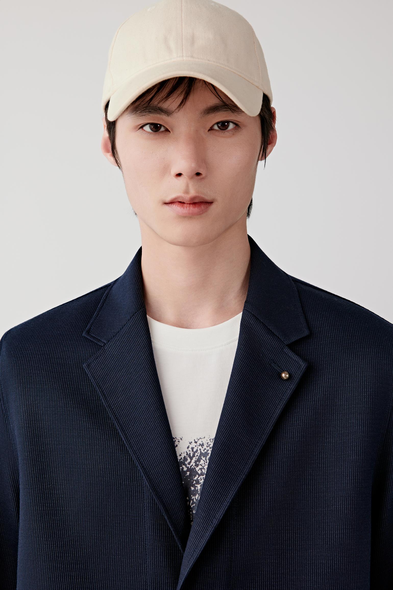 Close-up of the lapel and upper chest, revealing the subtle jacquard texture, soft surface and precise construction.