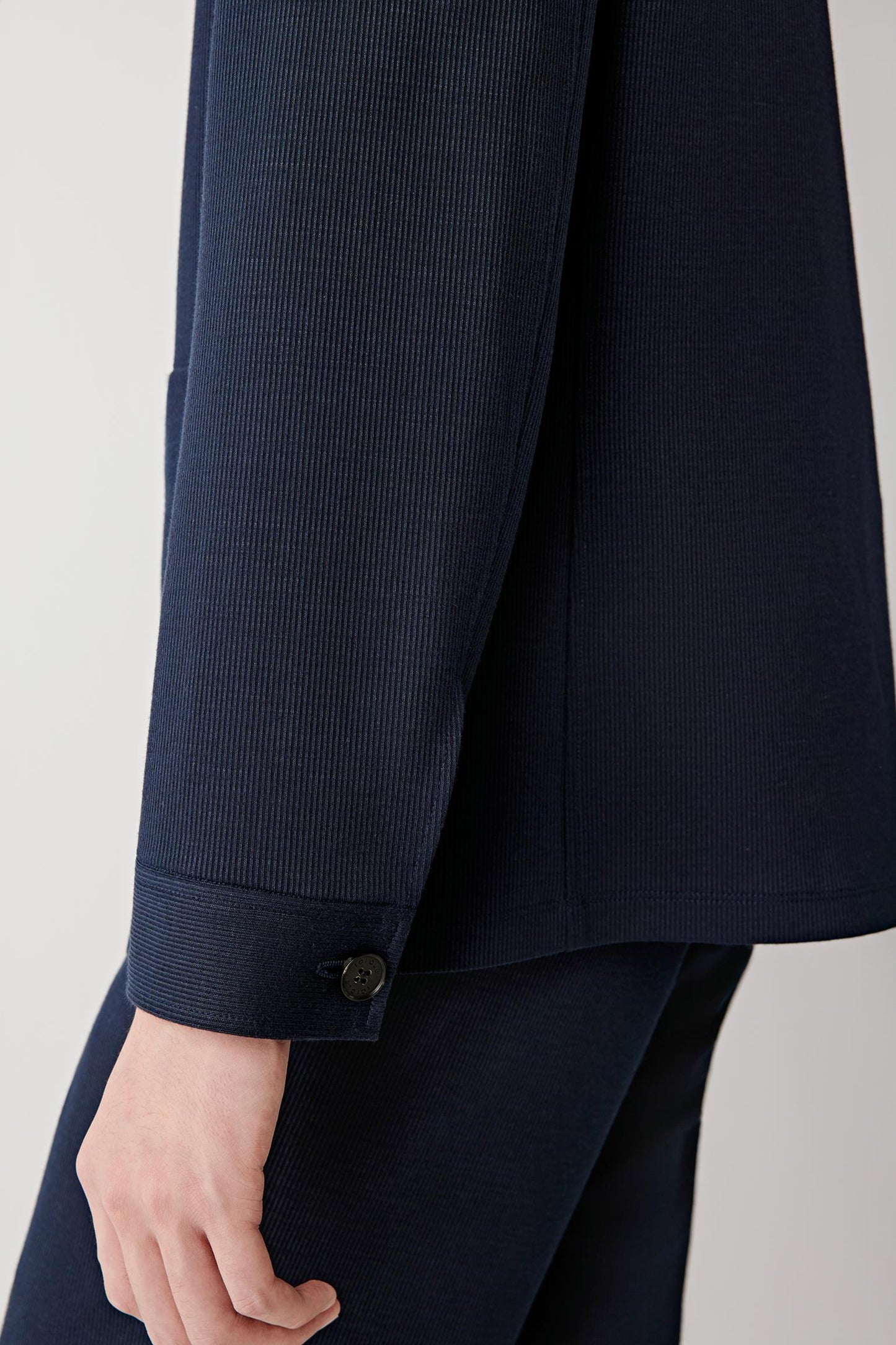 Detail of the sleeve and cuff, highlighting the clean finishing, straight sleeve line and lightweight fabric structure.