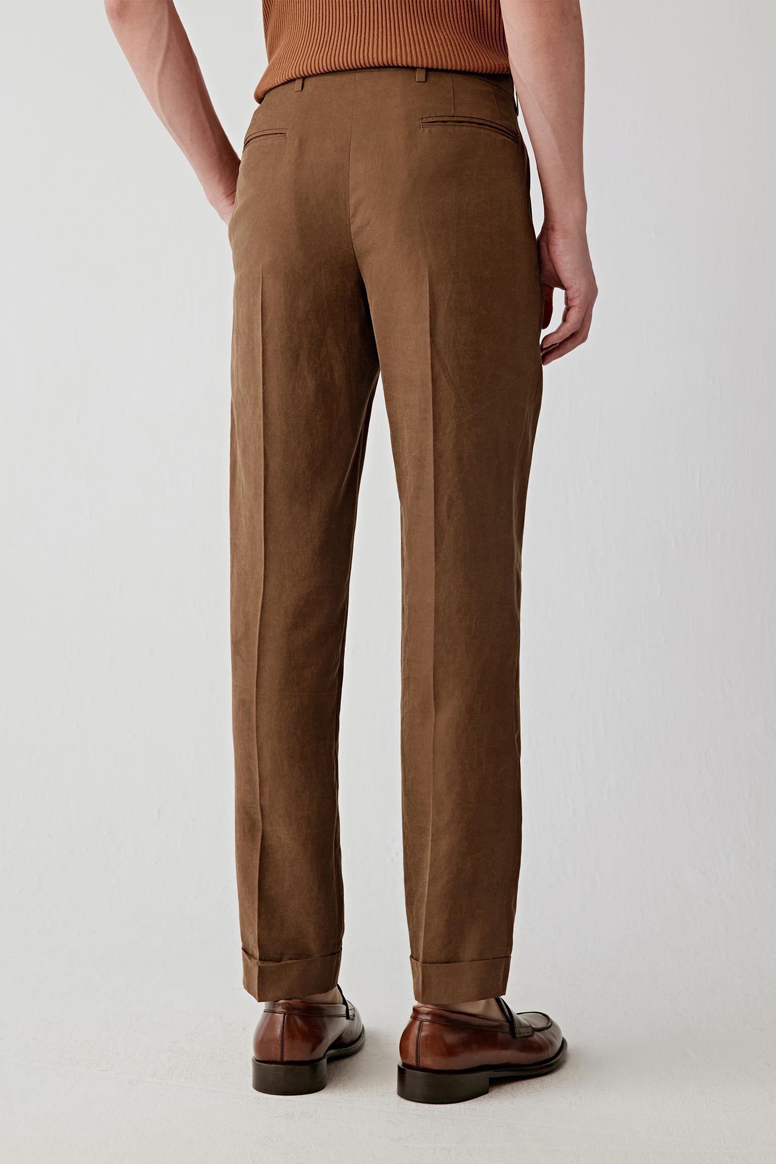 Full-length back view showing the rear silhouette, highlighting the straight cut and continuous vertical fall from waistband to hem, with discreet back pockets, visible stitching and a balanced structure maintaining shape while allowing natural movement
