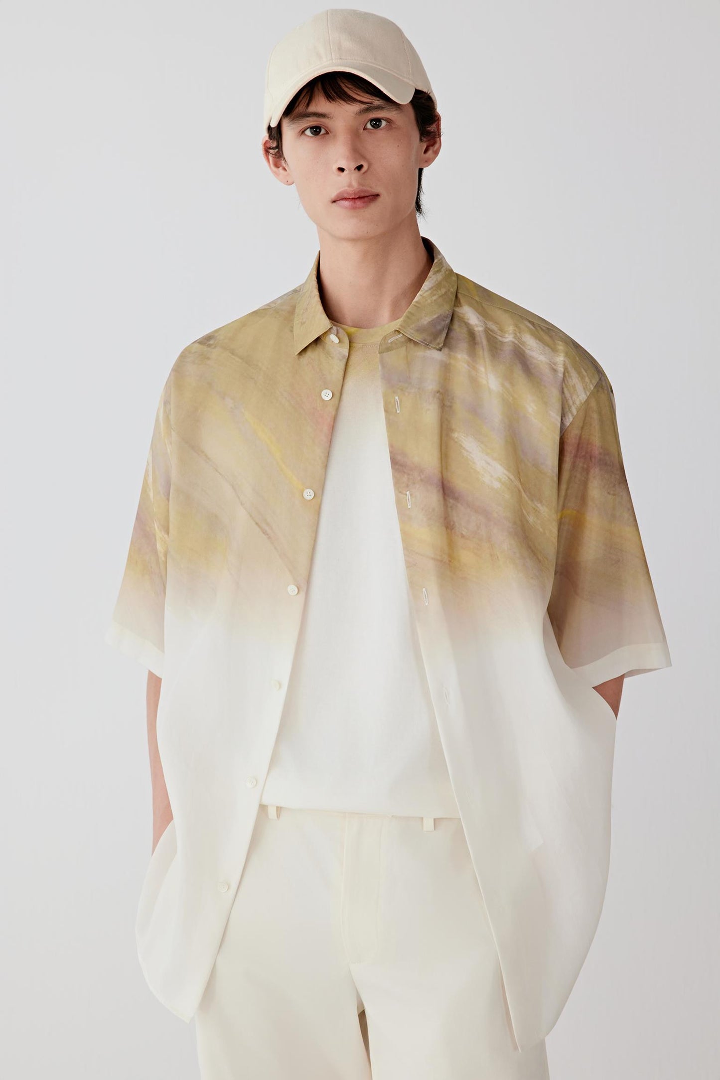 Front view of a man wearing a shirt in silk taffeta with warm beige tones and a lighter gradient effect, highlighting the smooth compact surface, crisp hand and subtle sheen of the fabric.