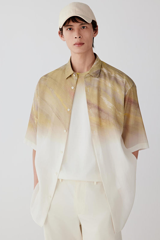 Front view of a man wearing a shirt in silk taffeta with warm beige tones and a lighter gradient effect, highlighting the smooth compact surface, crisp hand and subtle sheen of the fabric.