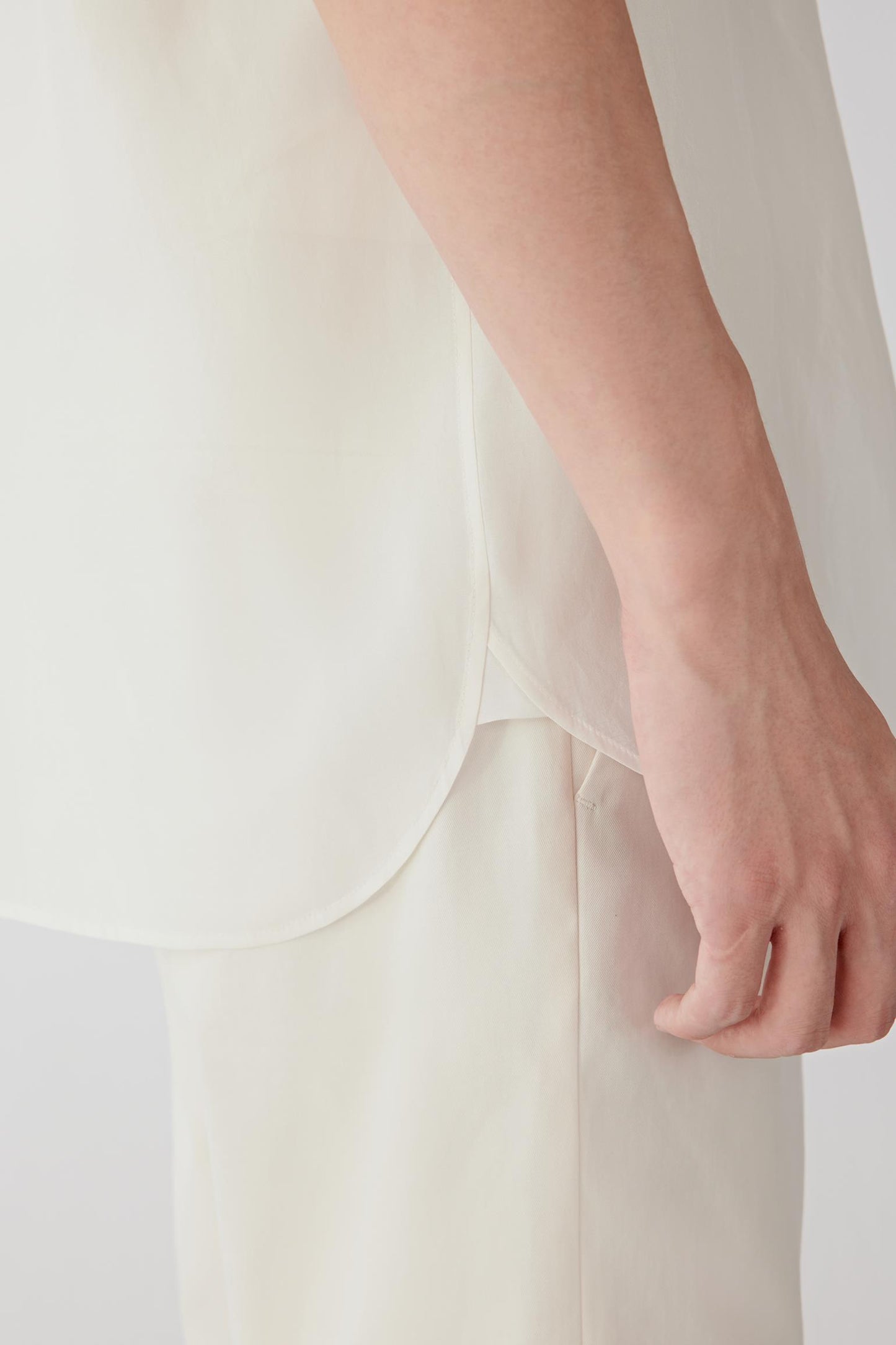 Close-up of the sleeve and fabric texture showing the compact weave, crisp structure and softly reflective finish characteristic of silk taffeta.