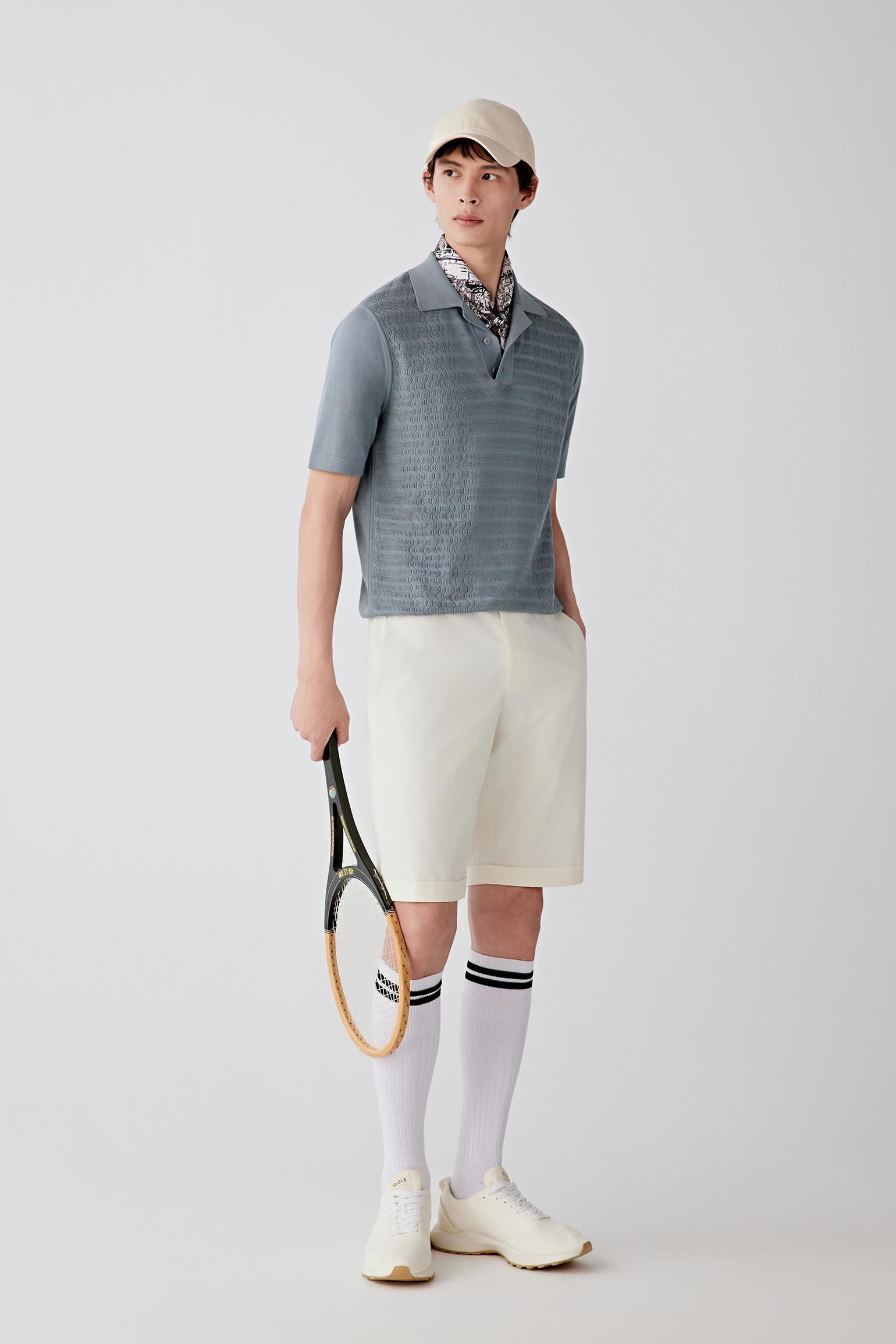 Full-length front view showing the relaxed silhouette, short sleeves and polo collar construction. The lightweight knit falls softly while maintaining a balanced and breathable structure.