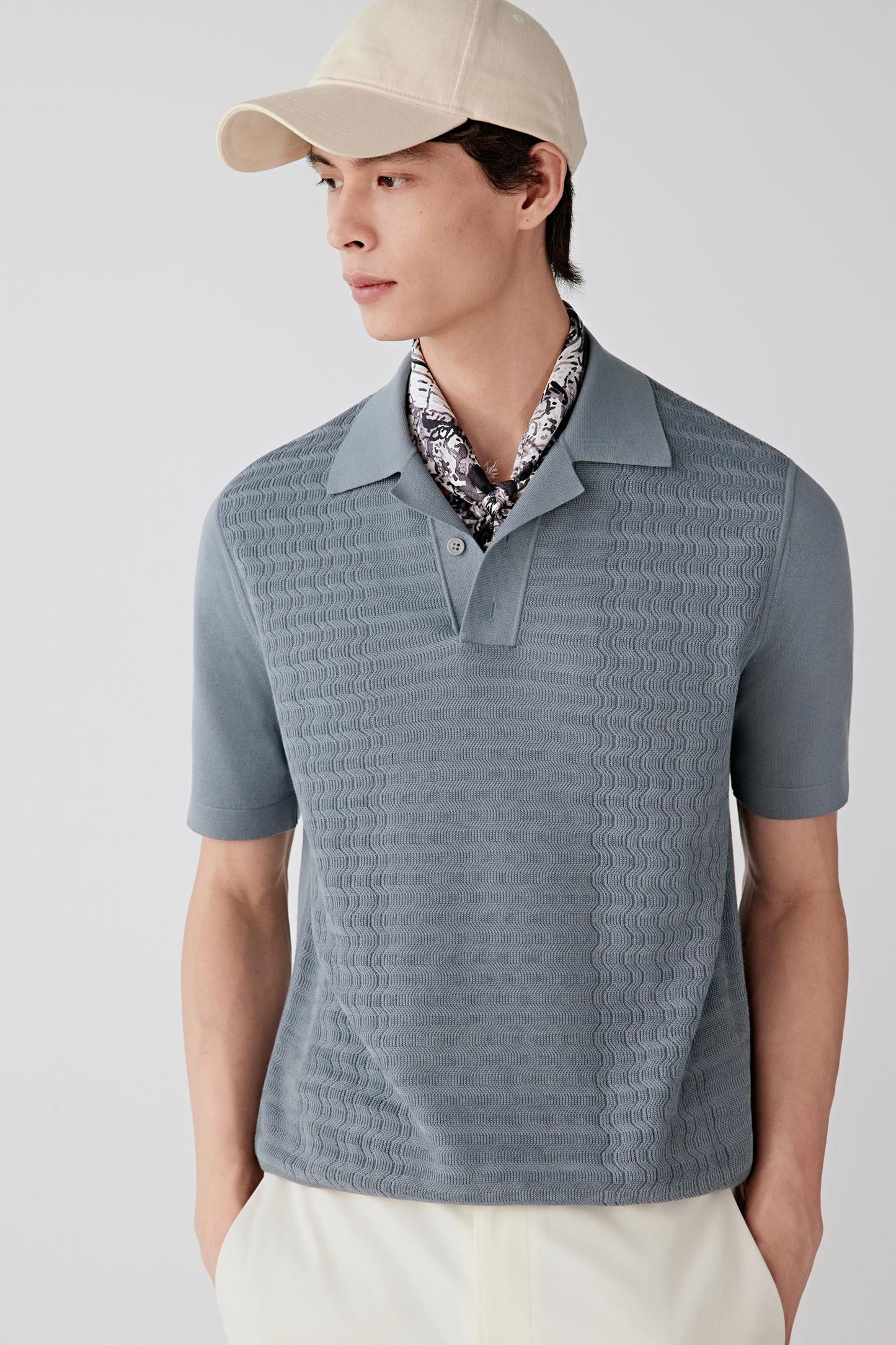 Front view of a man wearing a blue pullover in fine-spun cotton, highlighting the lightweight knit structure, smooth surface and soft hand of the fabric. The knit reveals a clean and even appearance with subtle tonal depth.