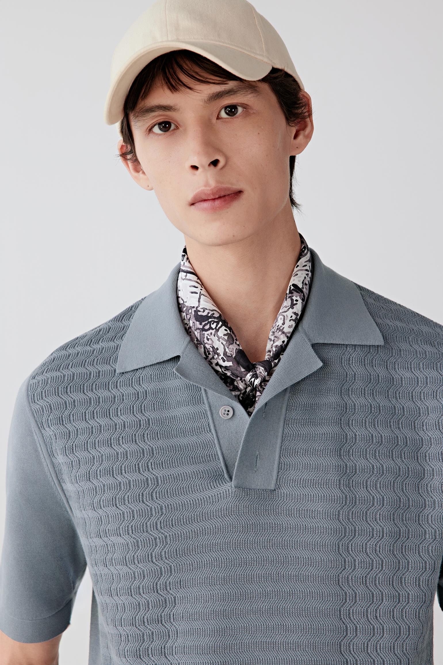 Close-up portrait focusing on the polo collar and neckline construction, detailing the fine knit texture, clean finishing and lightweight appearance of the cotton surface.