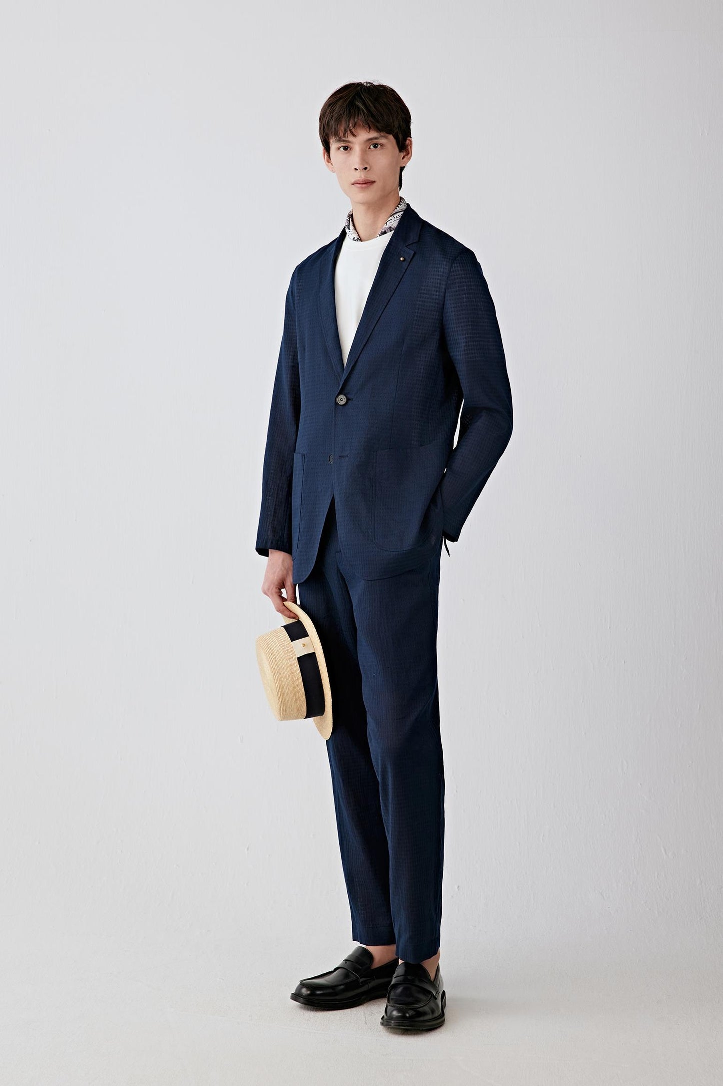 Full-length front view showing the straight silhouette, notch lapel and button fastening. The lightweight woven construction creates a relaxed tailored shape with fluid movement.
