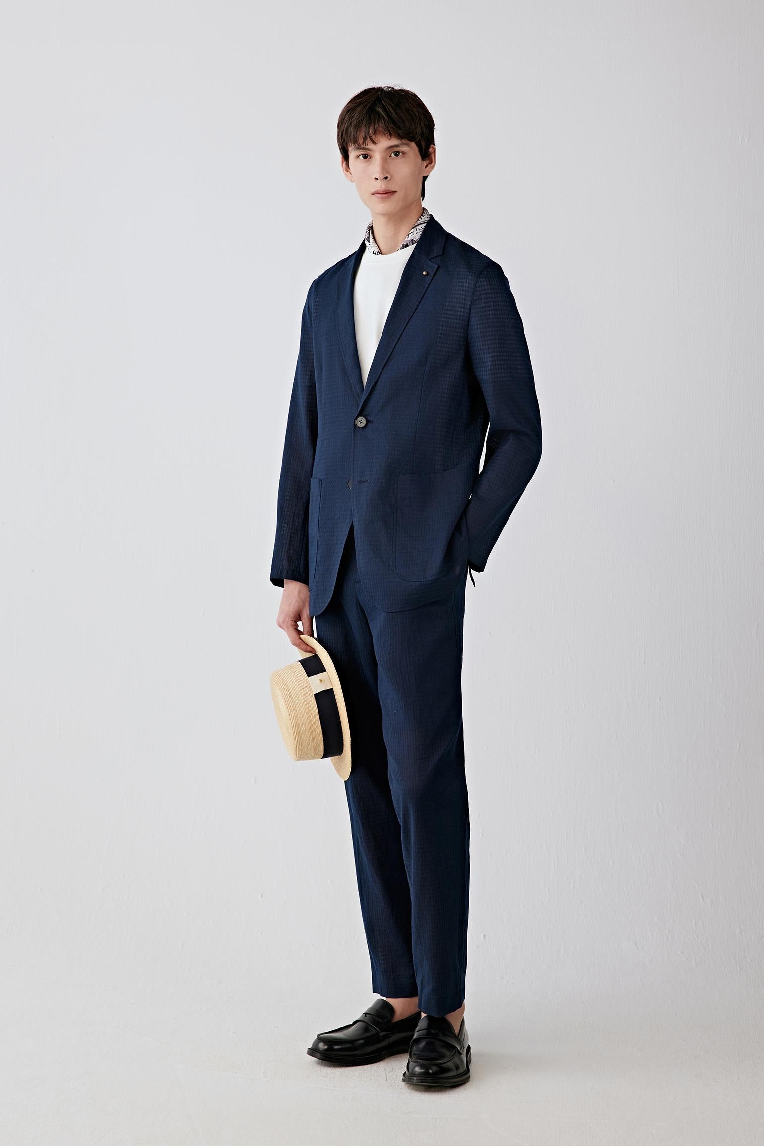 Full-length front view showing the straight silhouette, notch lapel and button fastening. The lightweight woven construction creates a relaxed tailored shape with fluid movement.