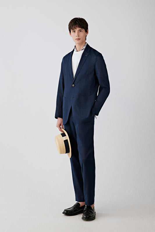 Full-length front view showing the straight silhouette, notch lapel and button fastening. The lightweight woven construction creates a relaxed tailored shape with fluid movement.