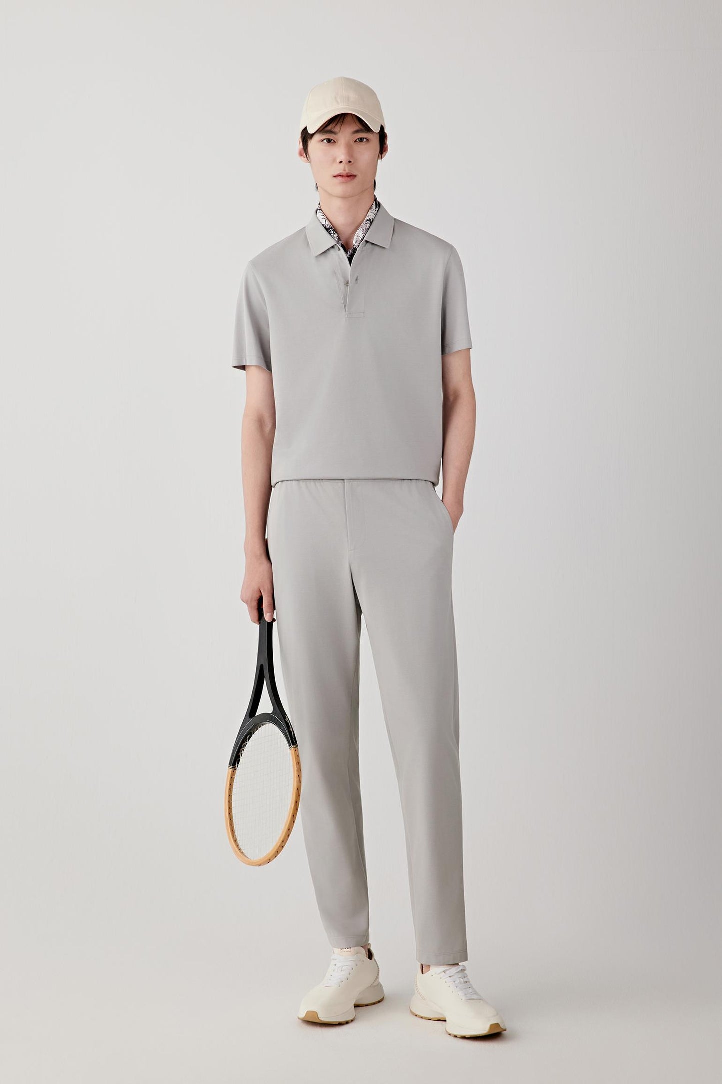 Front view of a man wearing silver grey drawstring trousers in cotton piqué jersey, highlighting the softly textured surface, lightweight structure and fluid drape of the fabric. The piqué construction introduces subtle texture and tonal depth.