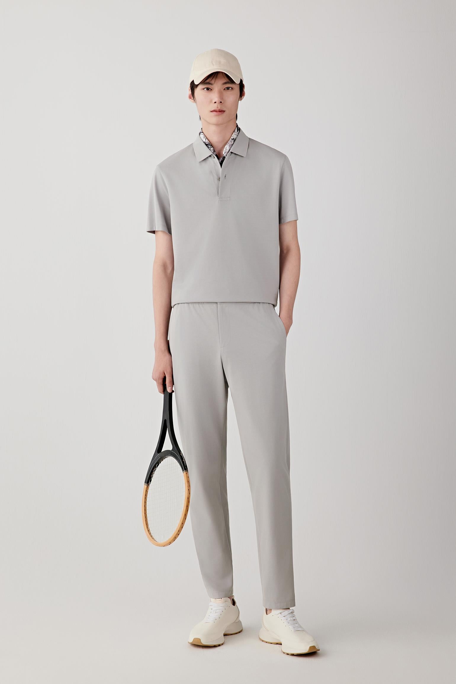 Front view of a man wearing silver grey drawstring trousers in cotton piqué jersey, highlighting the softly textured surface, lightweight structure and fluid drape of the fabric. The piqué construction introduces subtle texture and tonal depth.
