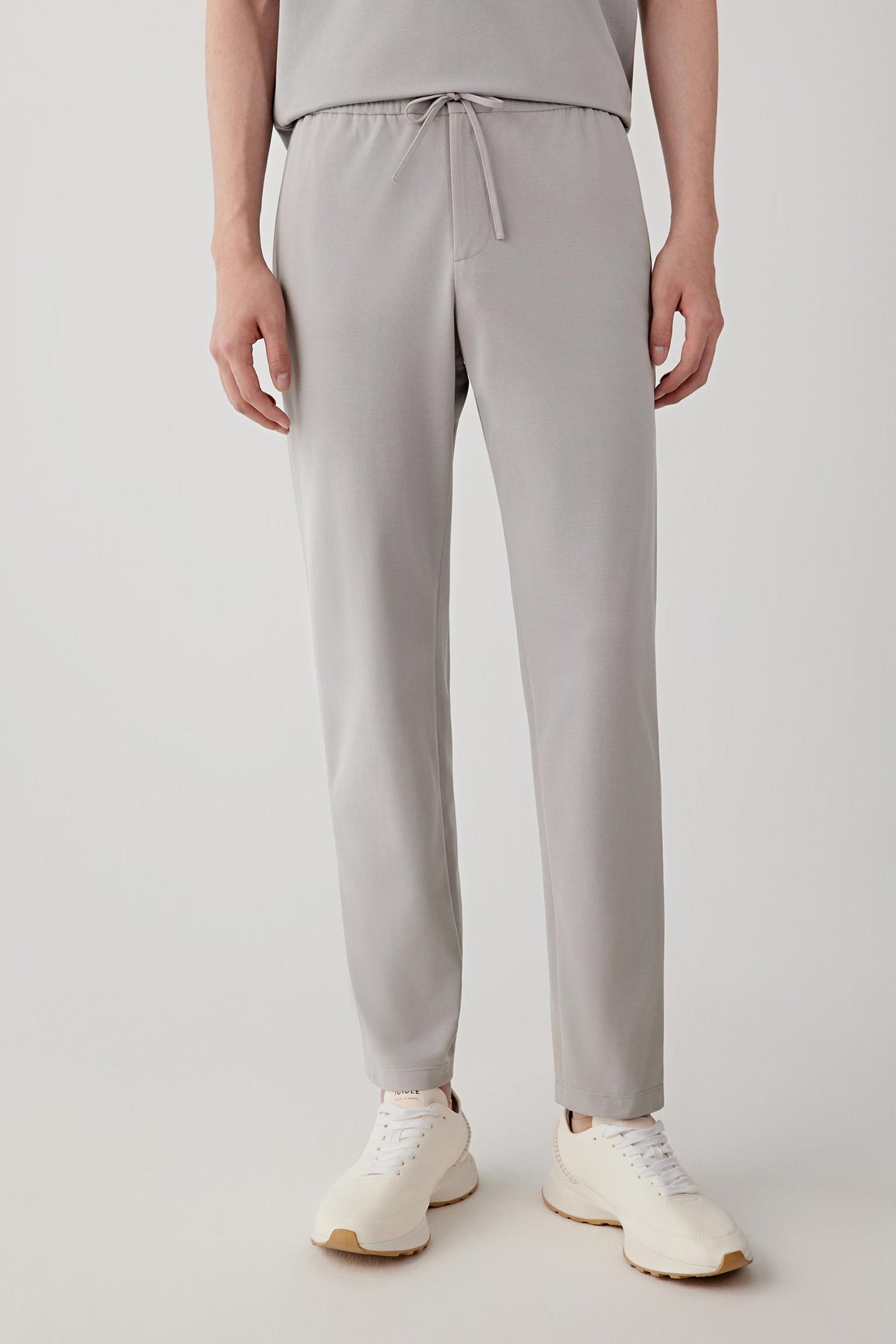 Mid-length front view showing the straight-leg silhouette, elasticated waistband and relaxed proportions. The trousers fall cleanly while maintaining a soft and comfortable structure.