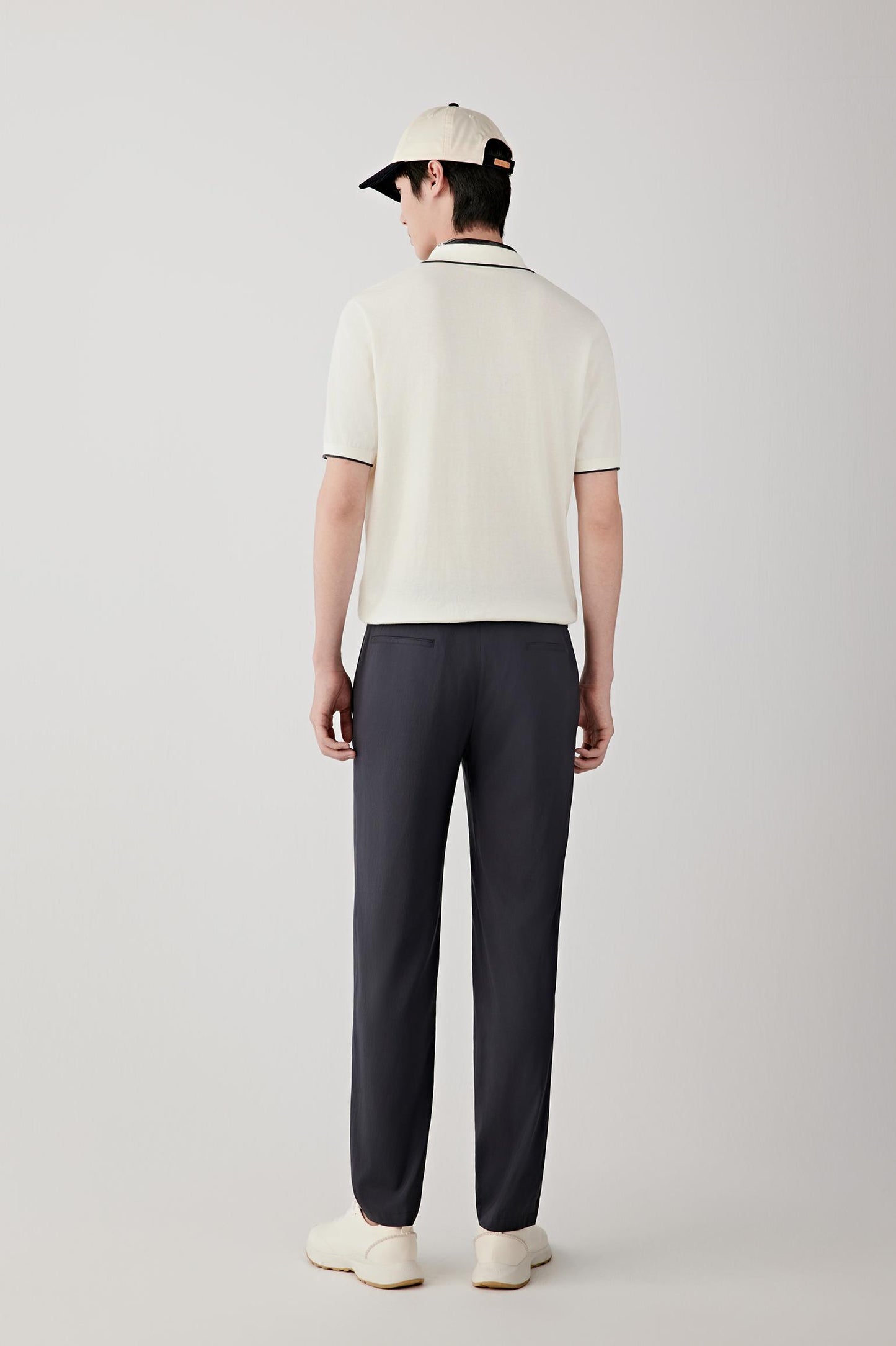 Full-length view highlighting the straight cut, lightweight structure and effortless fit of the polo shirt. The ivory shade and clean lines create a refined and understated appearance.