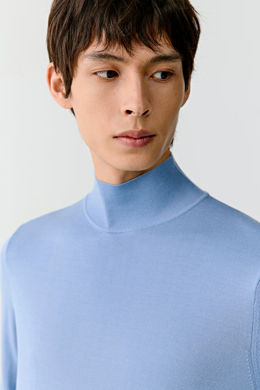 Portrait close-up showing the mock-neck collar and smooth superfine wool knit texture.