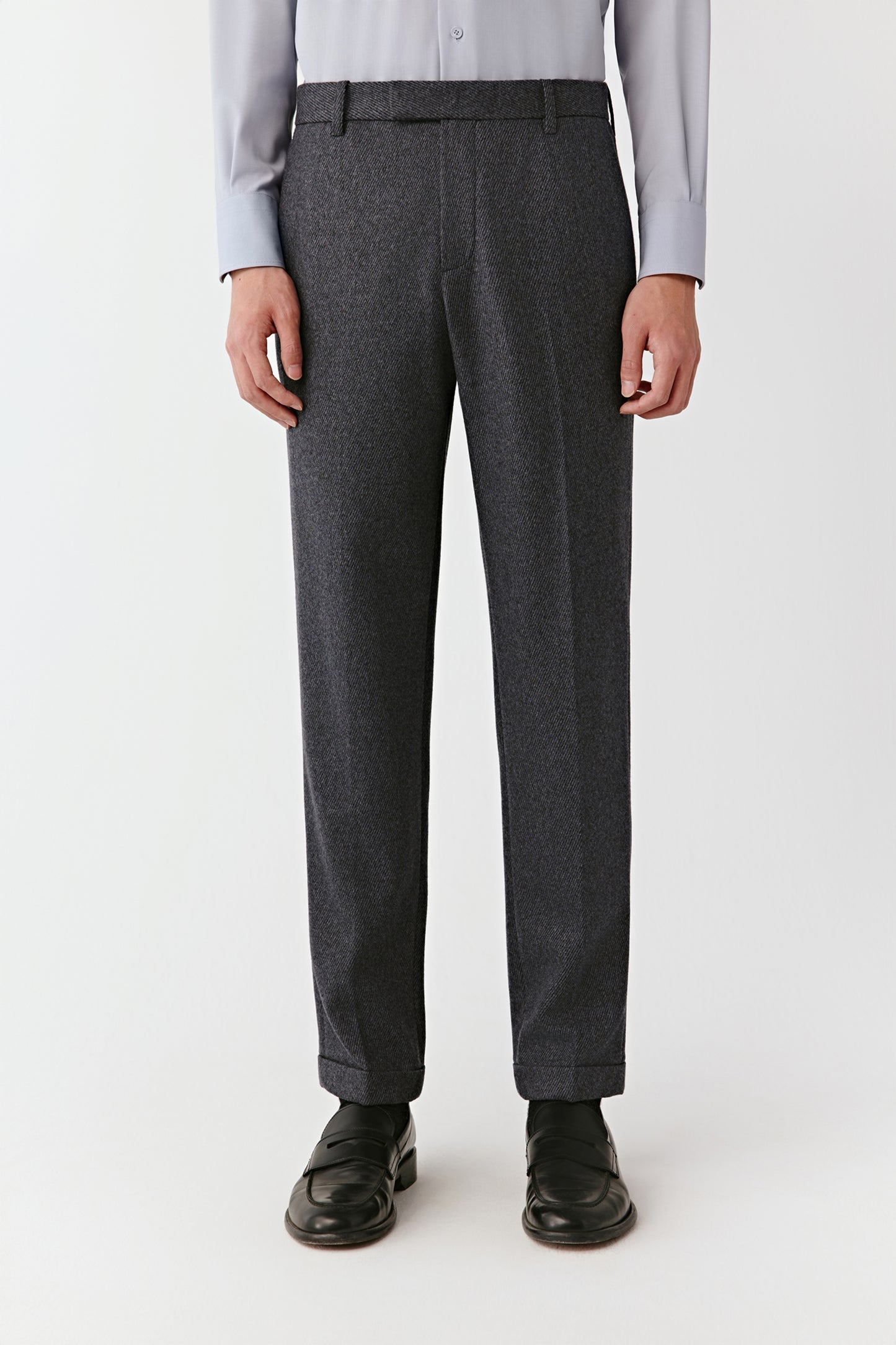 Person wearing gray dress pants on a white background