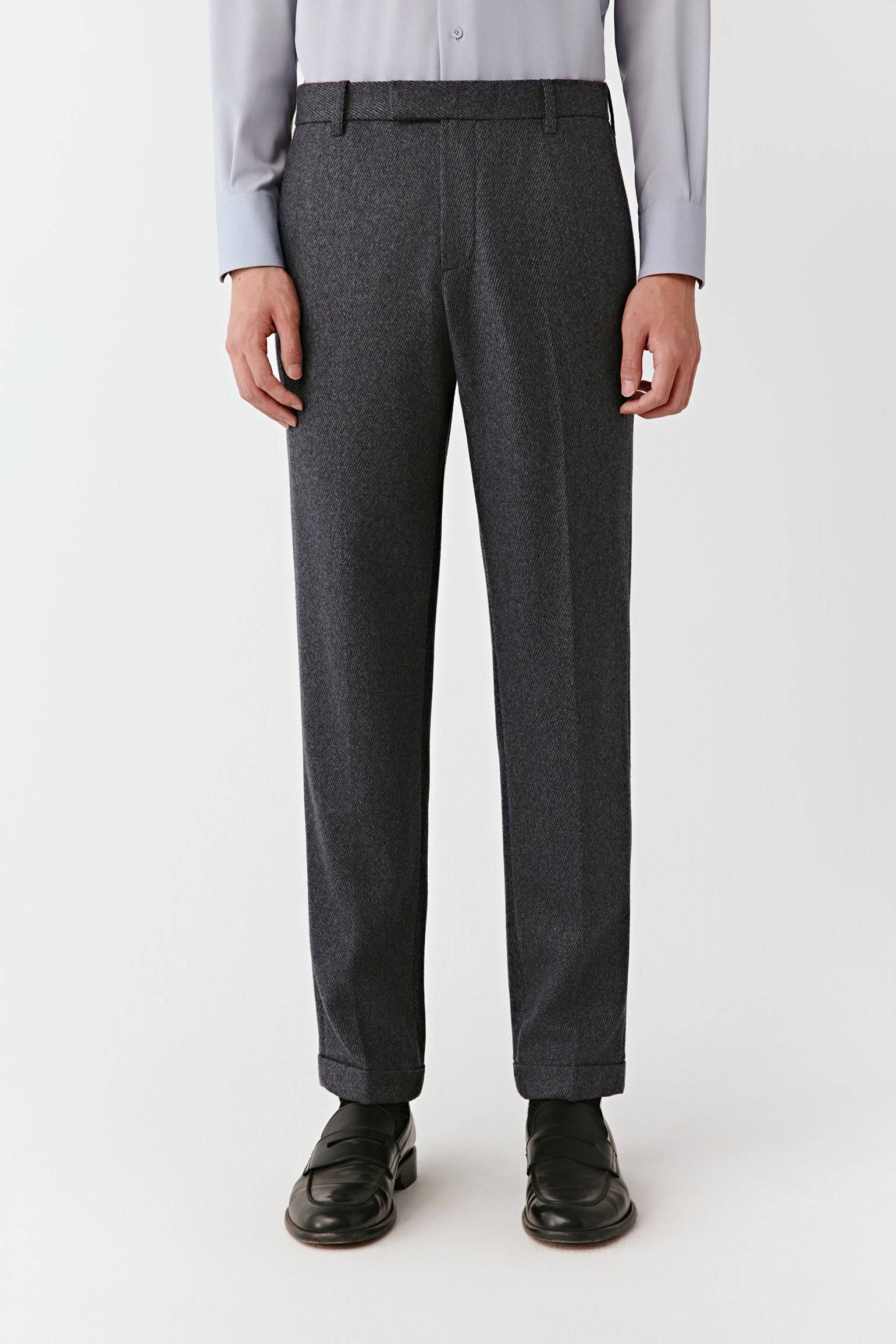 Person wearing gray dress pants on a white background