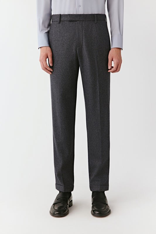 Person wearing gray dress pants on a white background
