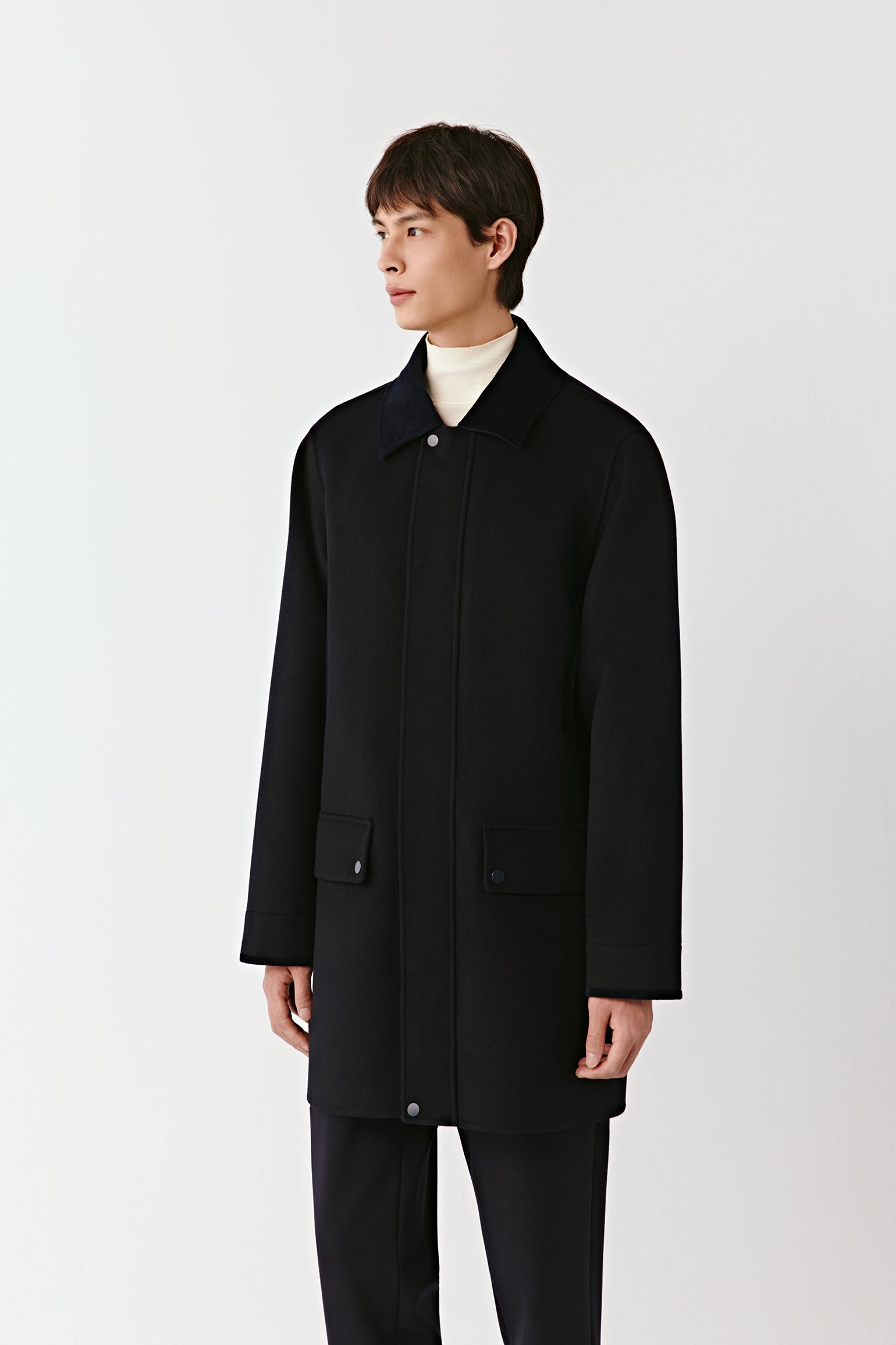 Person wearing a black coat on a white background