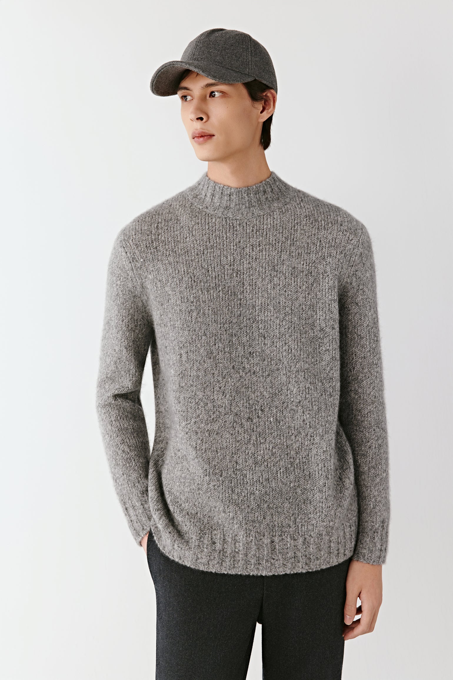 Man wearing a grey melange cashmere and silk mock-neck pullover with a straight, relaxed fit; mid-length front view highlighting the soft knit texture, clean lines and ribbed neckline.