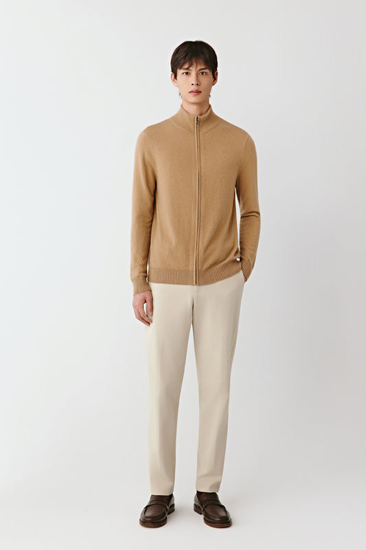Front view of the camel cashmere zip-up cardigan, straight fit with ribbed trims and stand collar, styled with light trousers.