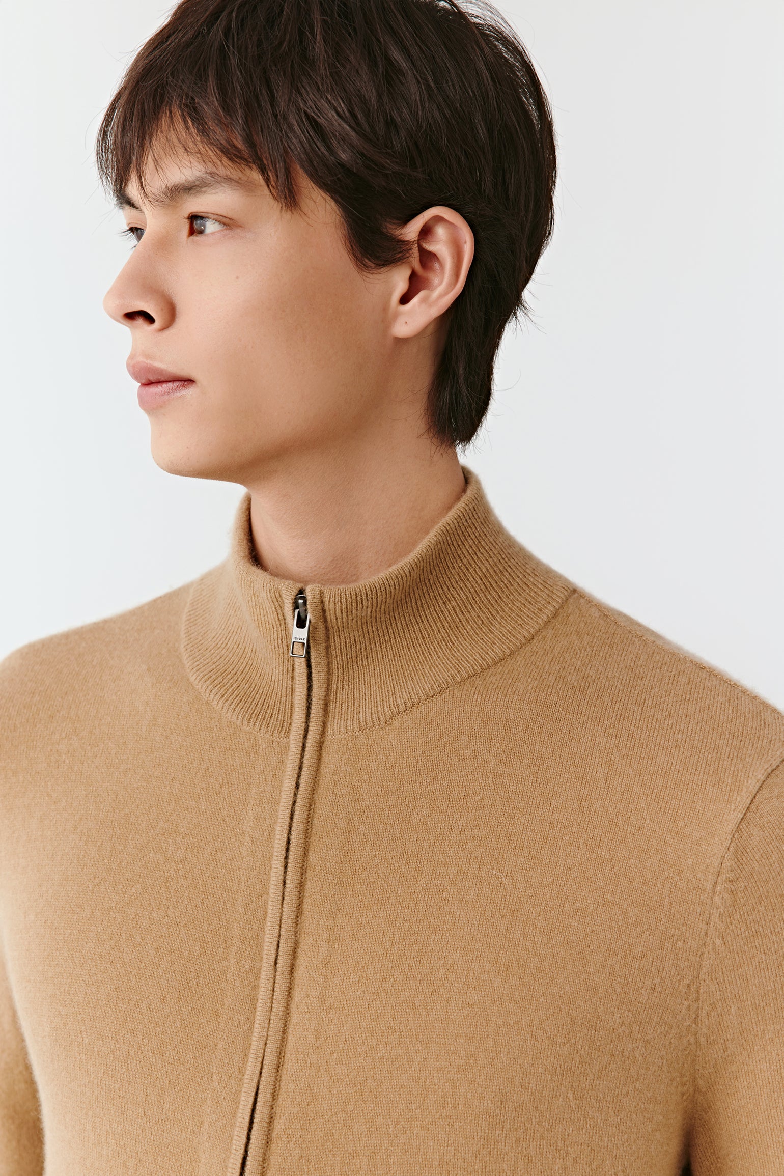 Close-up of the stand collar and full-length zip, showing the fine knit and subtle finishing.
