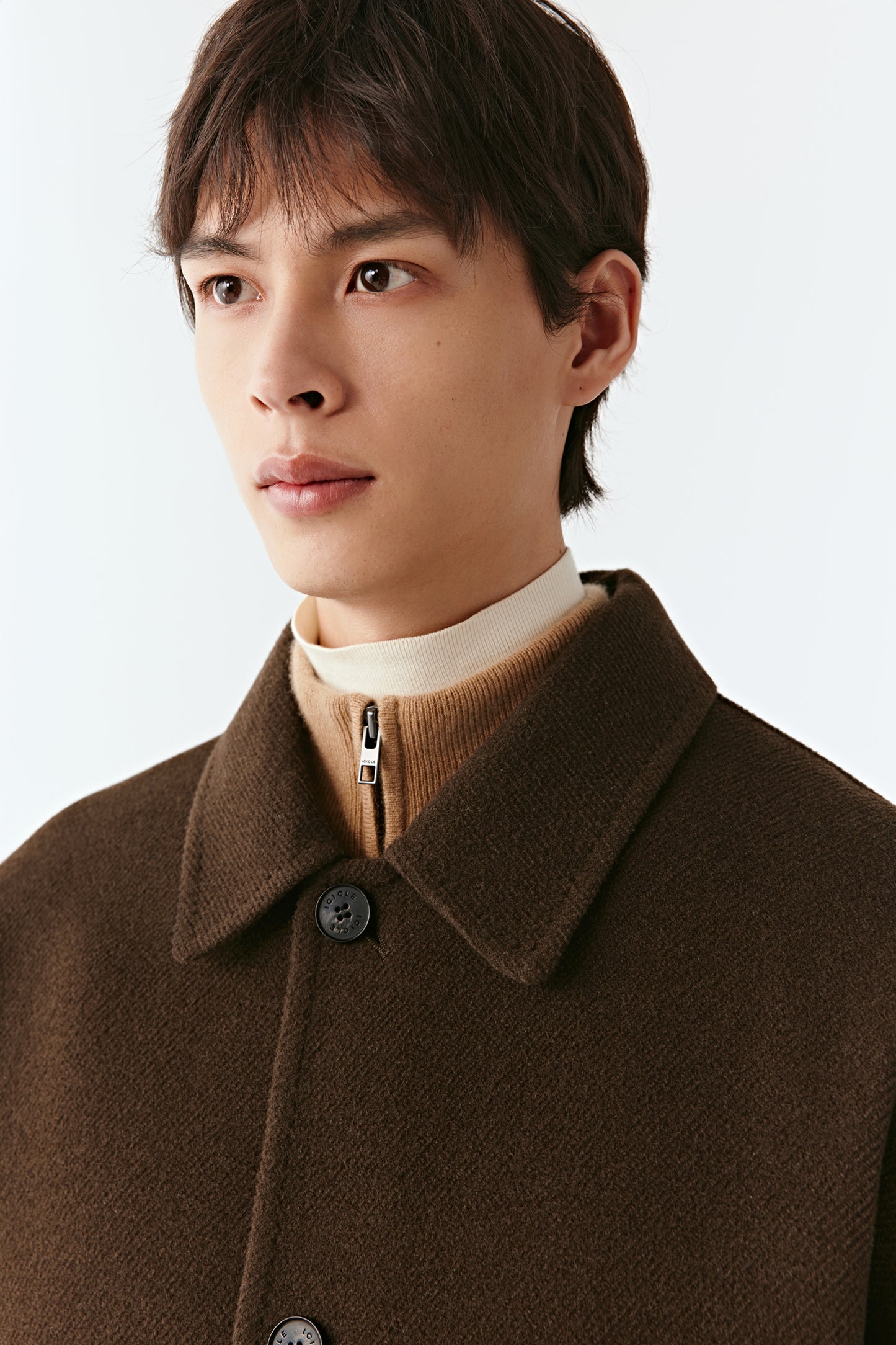 Close-up portrait of the upper part of the coat, highlighting the point collar, button placket, and fine twill weave.