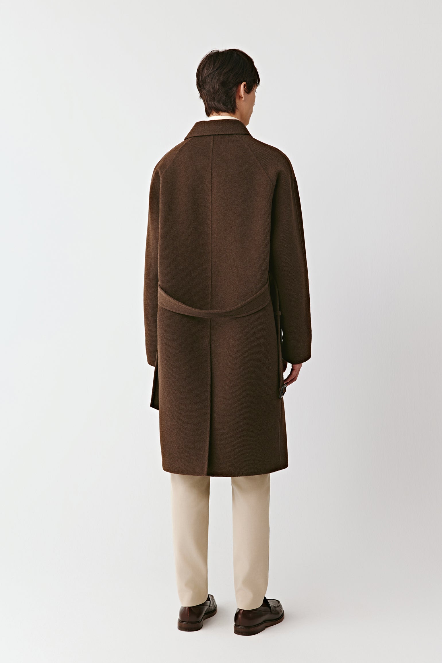 Back view of the brown double-faced yak wool coat, emphasizing the clean construction and natural flow of the fabric.