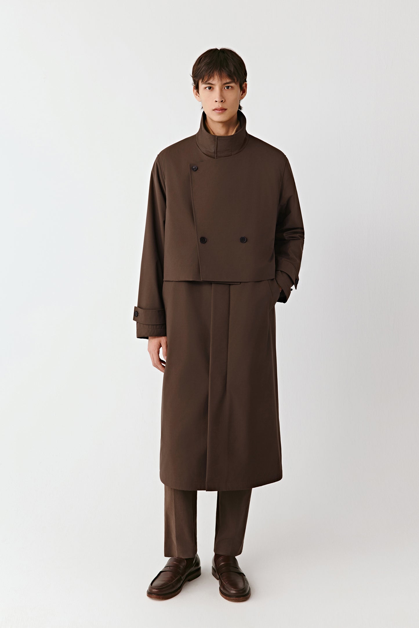 Front view of the walnut-brown quilted yak and worsted wool coat, long cut with a stand collar and cape-like bib detail.