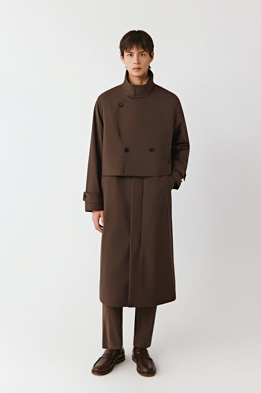 Front view of the walnut-brown quilted yak and worsted wool coat, long cut with a stand collar and cape-like bib detail.