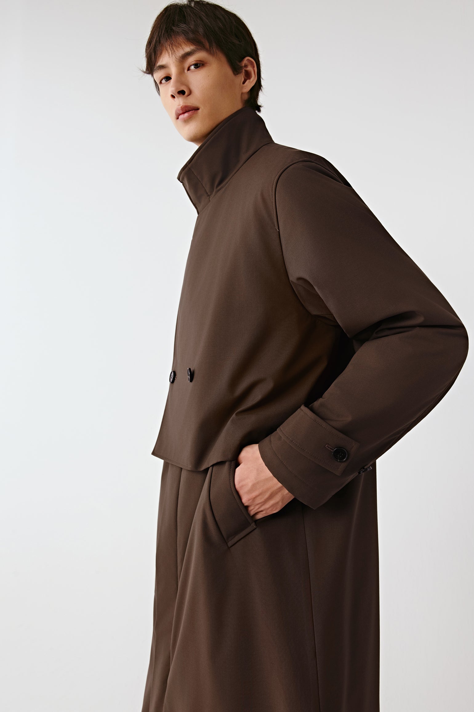 Back view of the coat, highlighting the clean lines and subtle quilting beneath the surface.