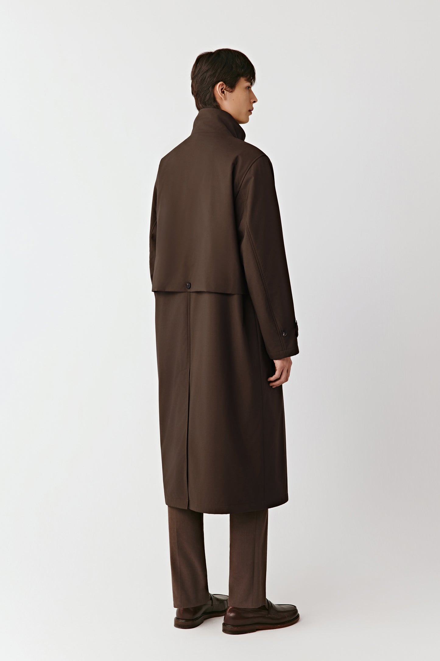 Close-up of the collar and button fastening, revealing the refined tailoring and smooth wool texture.