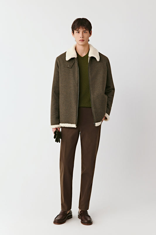 Front view of the khaki green wool and cashmere zip jacket, featuring a contrast collar, patch pockets, and straight silhouette, styled with dark trousers.