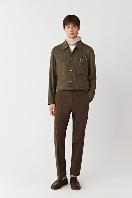 Front view of the brown stretch cotton twill trousers, straight leg with a pressed crease and belted waistband.