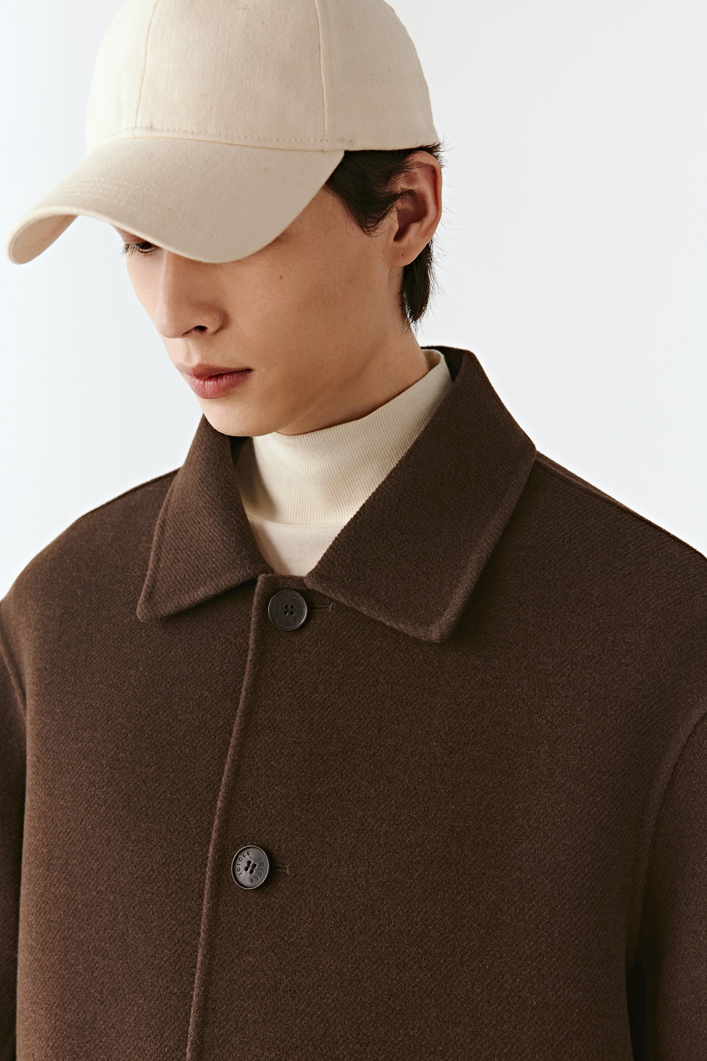 Close-up portrait of the chestnut brown jacket, focusing on the shirt collar and button placket.