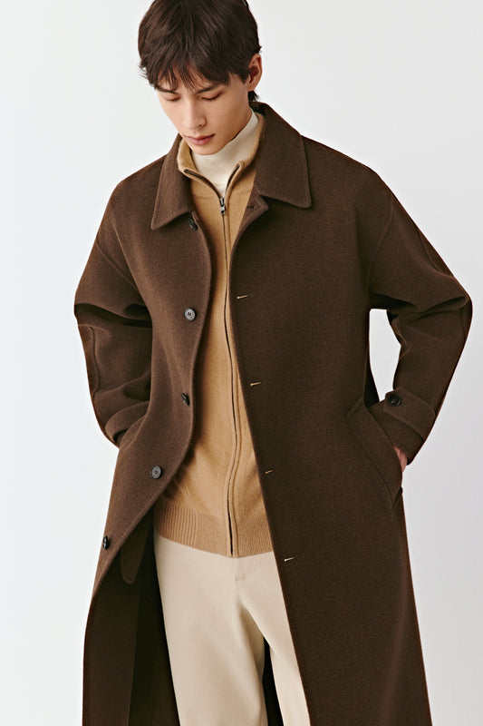 Three-quarter side view of the yak wool coat, showing the elegant length, smooth drape, and discreet button fastening.