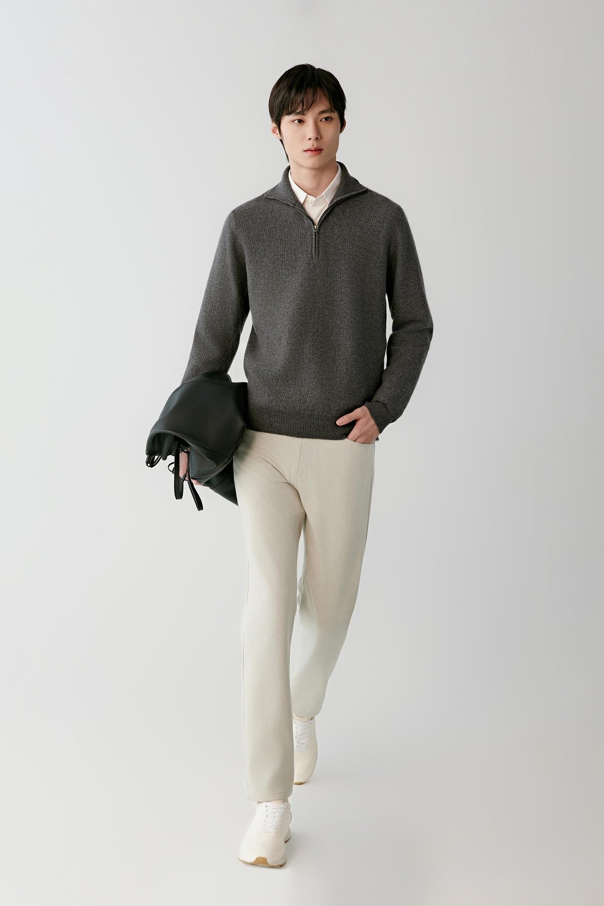 Front view of a man wearing a smoke grey cashmere pullover, showing the half-zip high collar, long sleeves and straight silhouette.