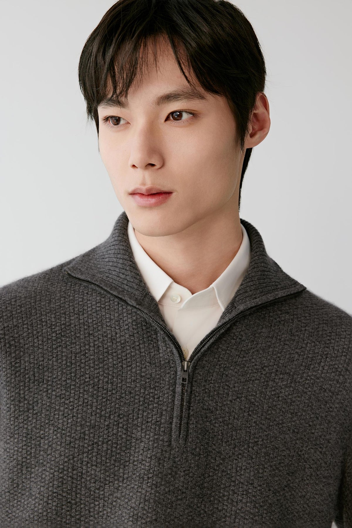 Close-up highlighting the half-zip high collar and textured smoke grey cashmere knit.