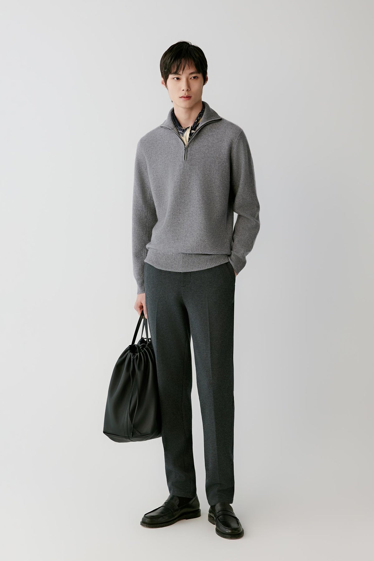 Front view of a man wearing a grey cashmere pullover, showing the half-zip funnel neck, long sleeves and straight silhouette.