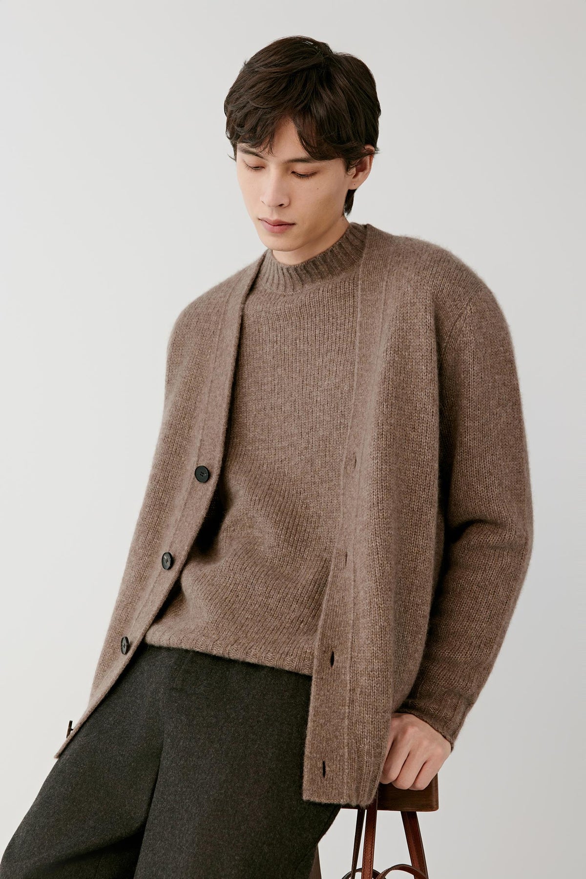 Three-quarter view of a man wearing the warm brown cashmere pullover, showing the round neckline, long sleeves and straight silhouette.