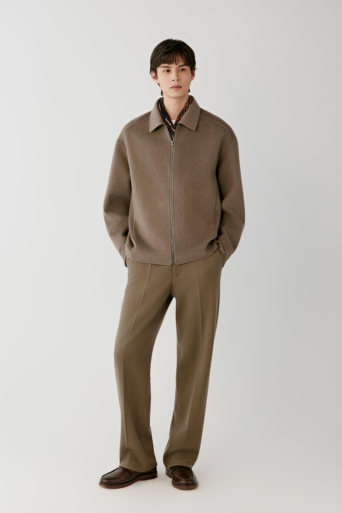 Front full-length view of a man wearing the brown melange cashmere jacket, highlighting the straight silhouette and long sleeves.
