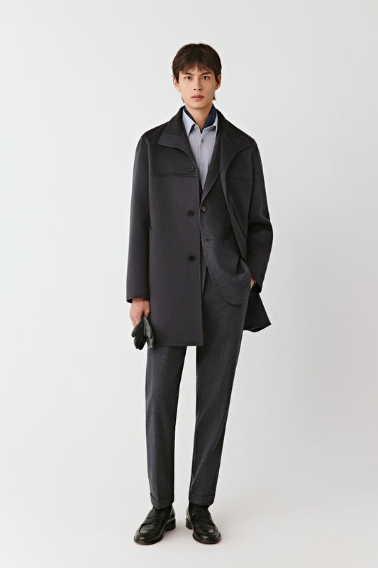 Man wearing a gray coat and pants on a white background