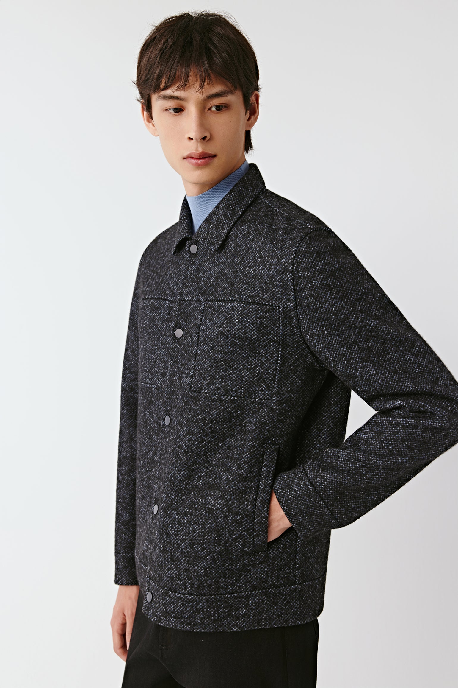 Man wearing a dark gray jacket against a white background