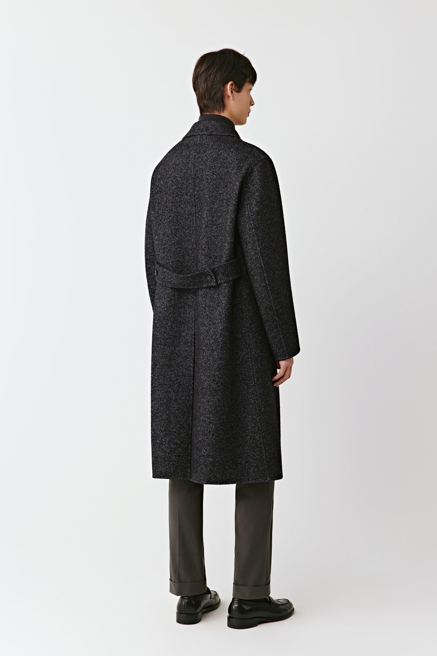 Person wearing a dark gray coat on a white background