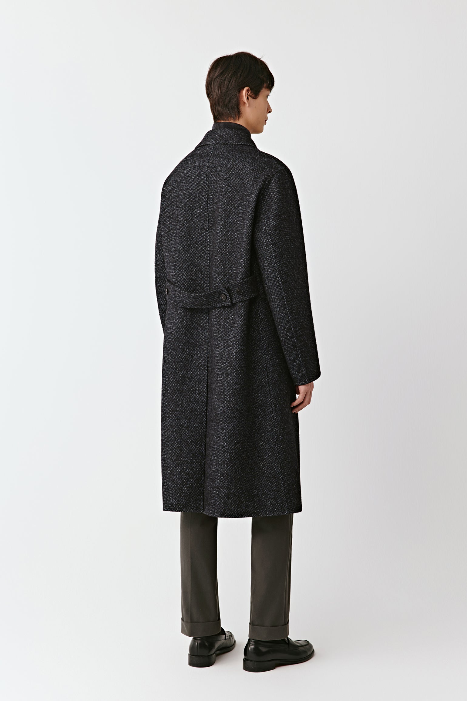 Person wearing a dark gray coat on a white background