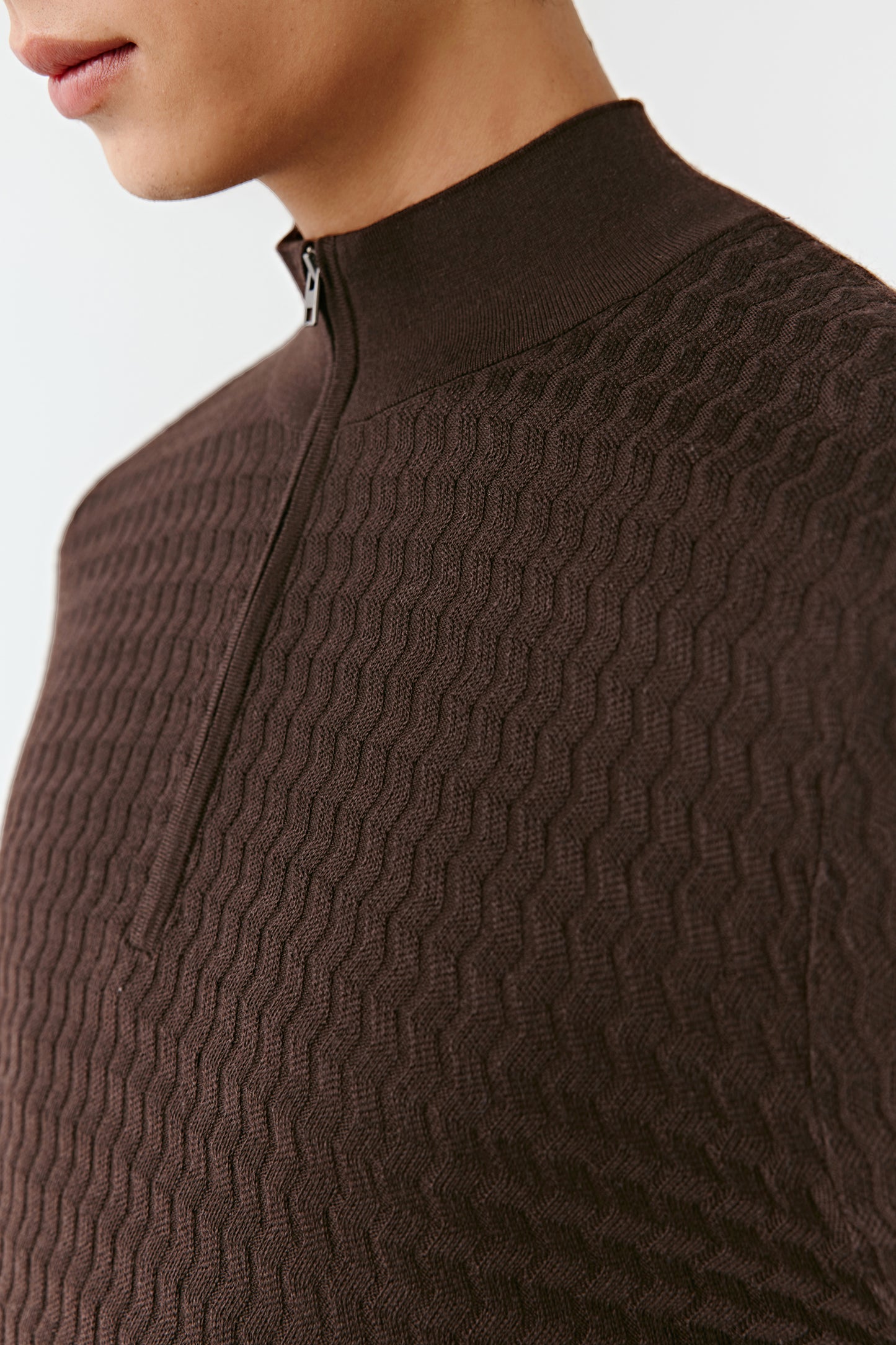 Close-up of a brown textured sweater with a zipper.