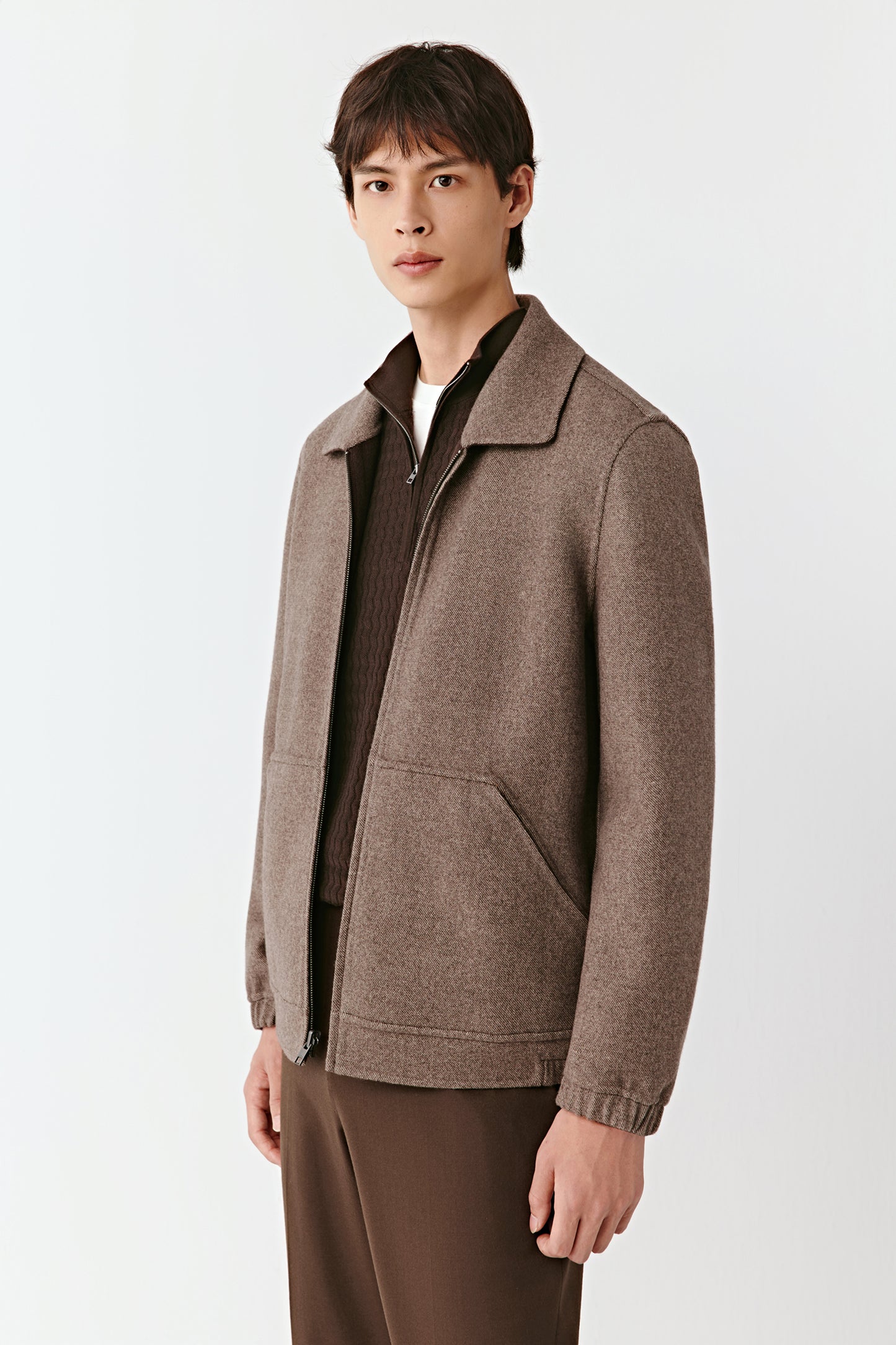 Man wearing a brown jacket on a white background