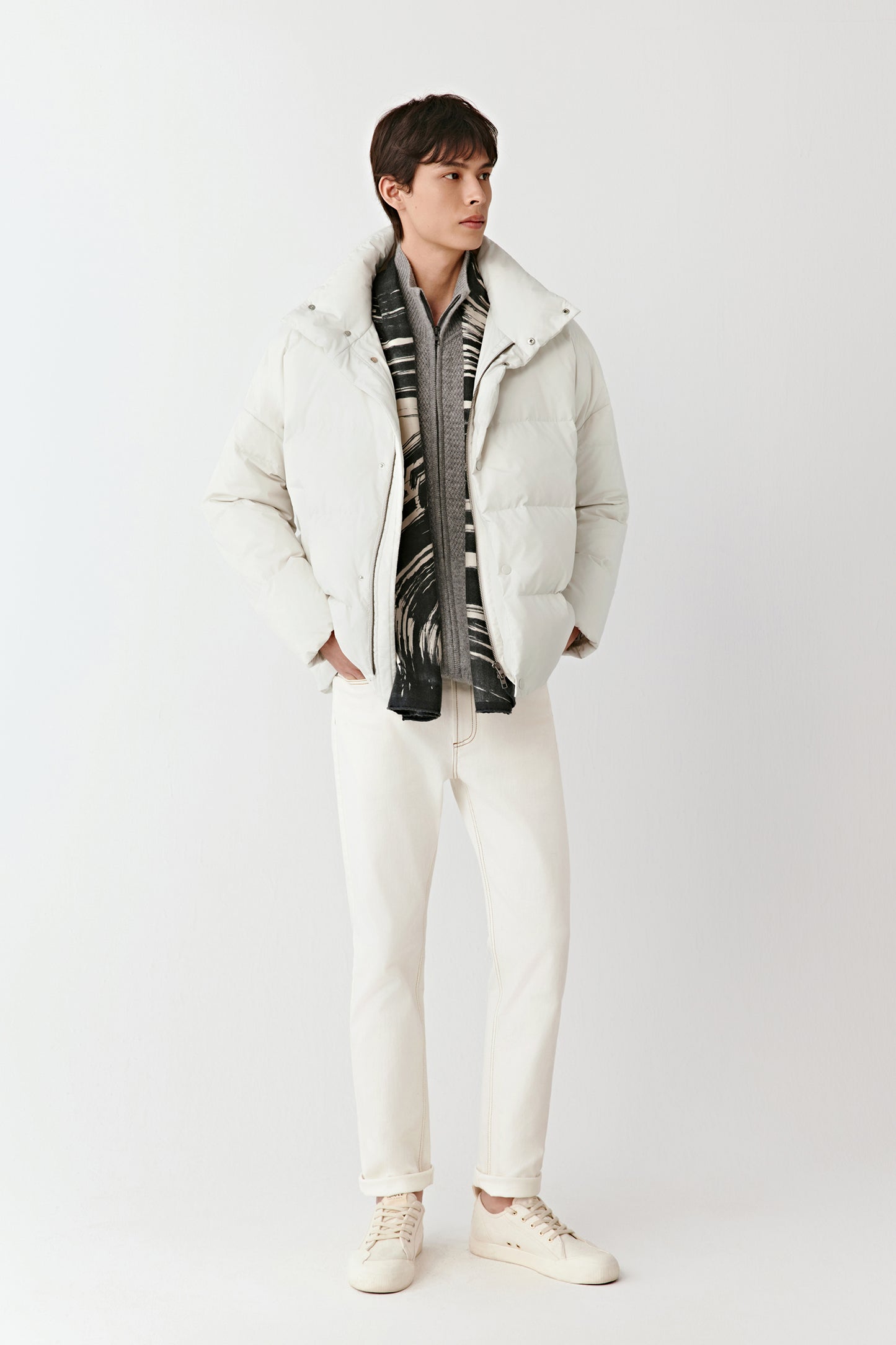Three-quarter view of the cream puffer coat, showing the zip fastening concealed by a press-stud placket.